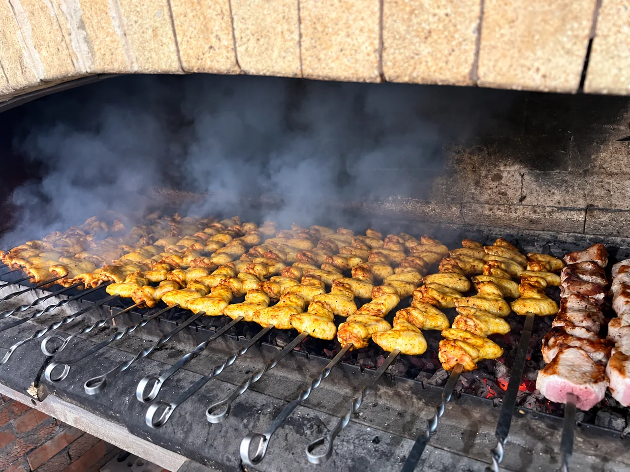 Настоящее приготовление шашлыка на большом мангале: шампуры с мясом над горячими углями